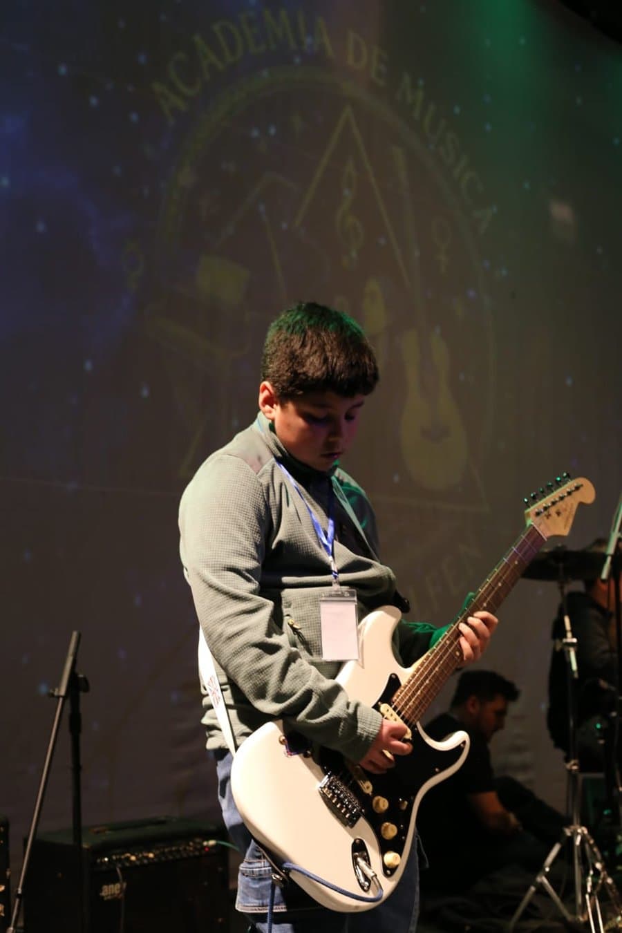 Alumno tocando una guitarra eléctrica blanca